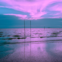 A picture of a beach with a purple sky 